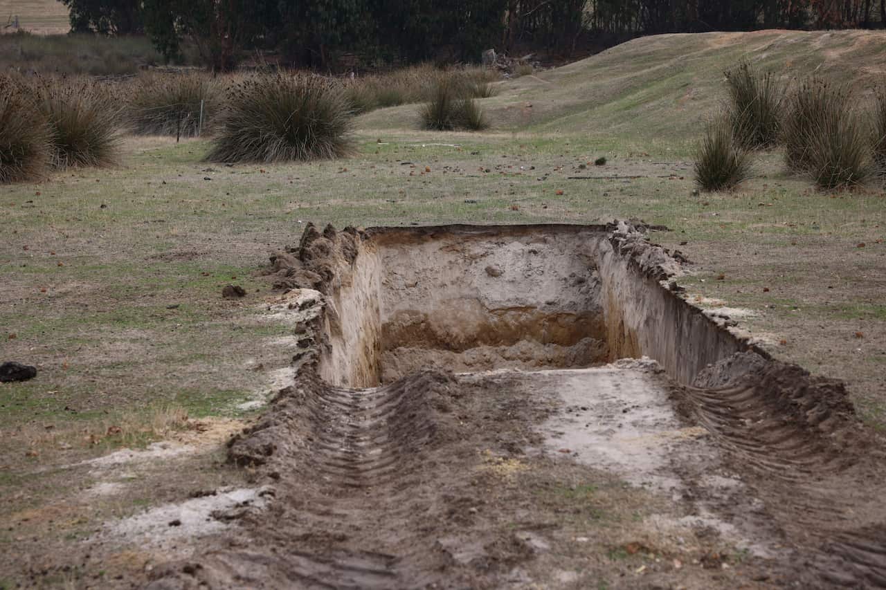 A burial site for sheep among rural farmland.