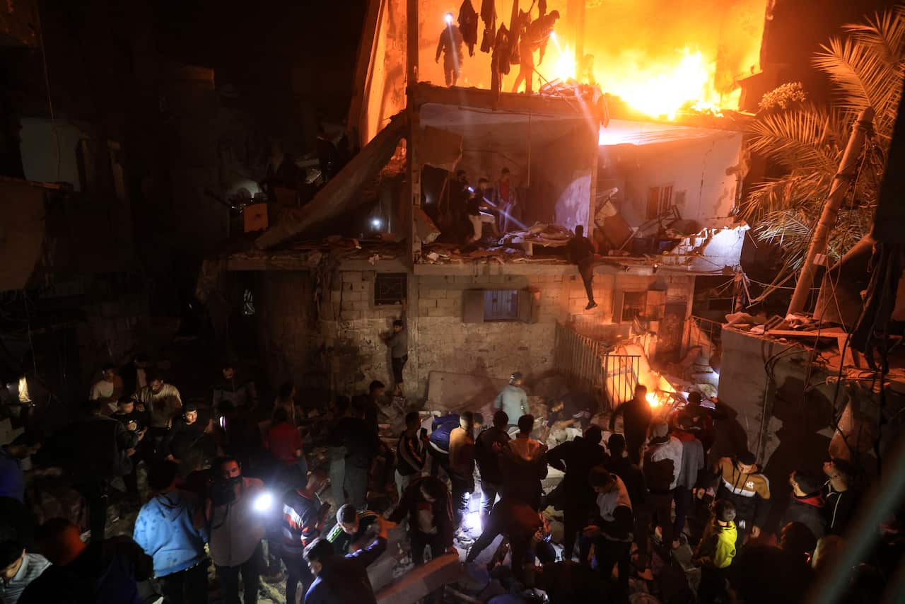 People search a destroyed building for survivors in Gaza.