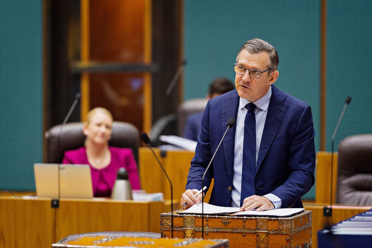A man standing at a microphone speaking.