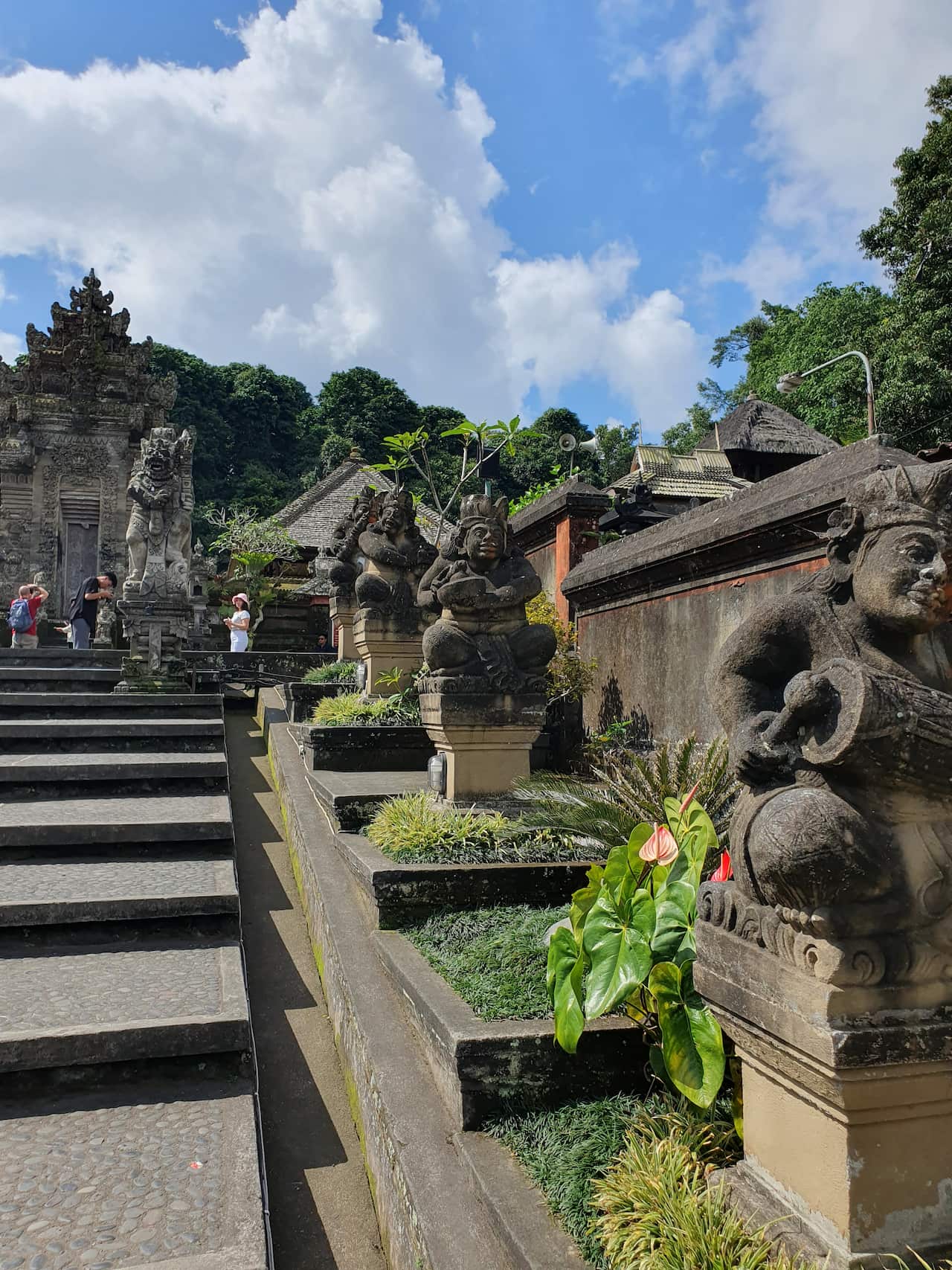 Stone statues along site walkway at Penglipuran village