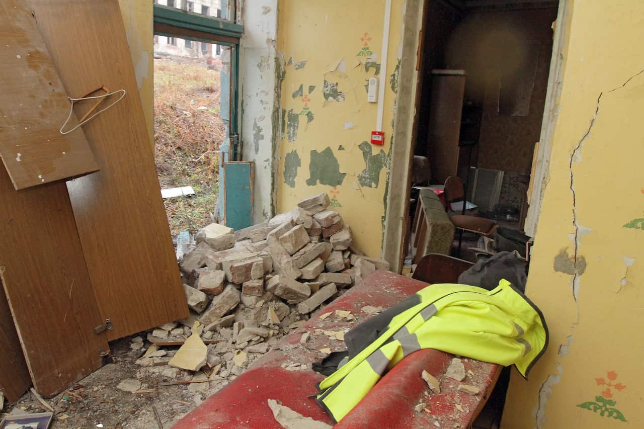 Scattered bricks and rubble inside a house.