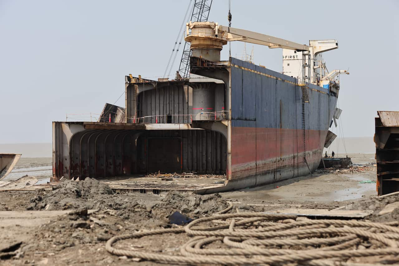 A cargo ship that is in the process of being broken up.