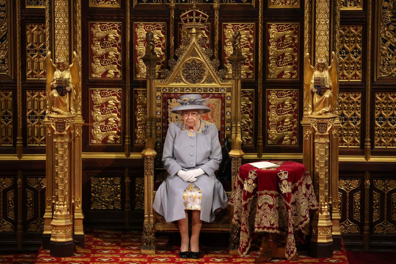 Queen Elizabeth sits on a gold throne at the House of Lords