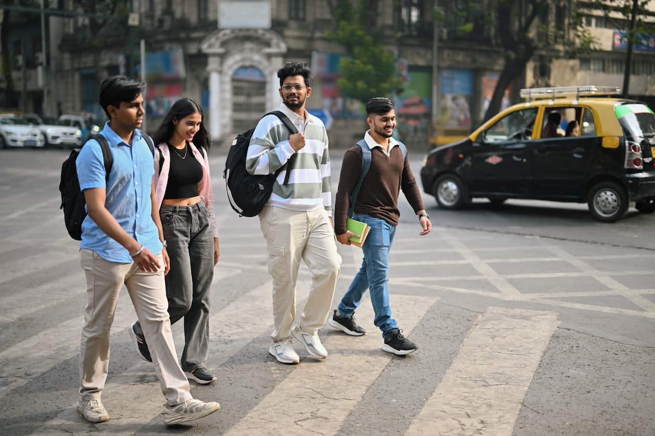 Group of young men and woman students crossing the road