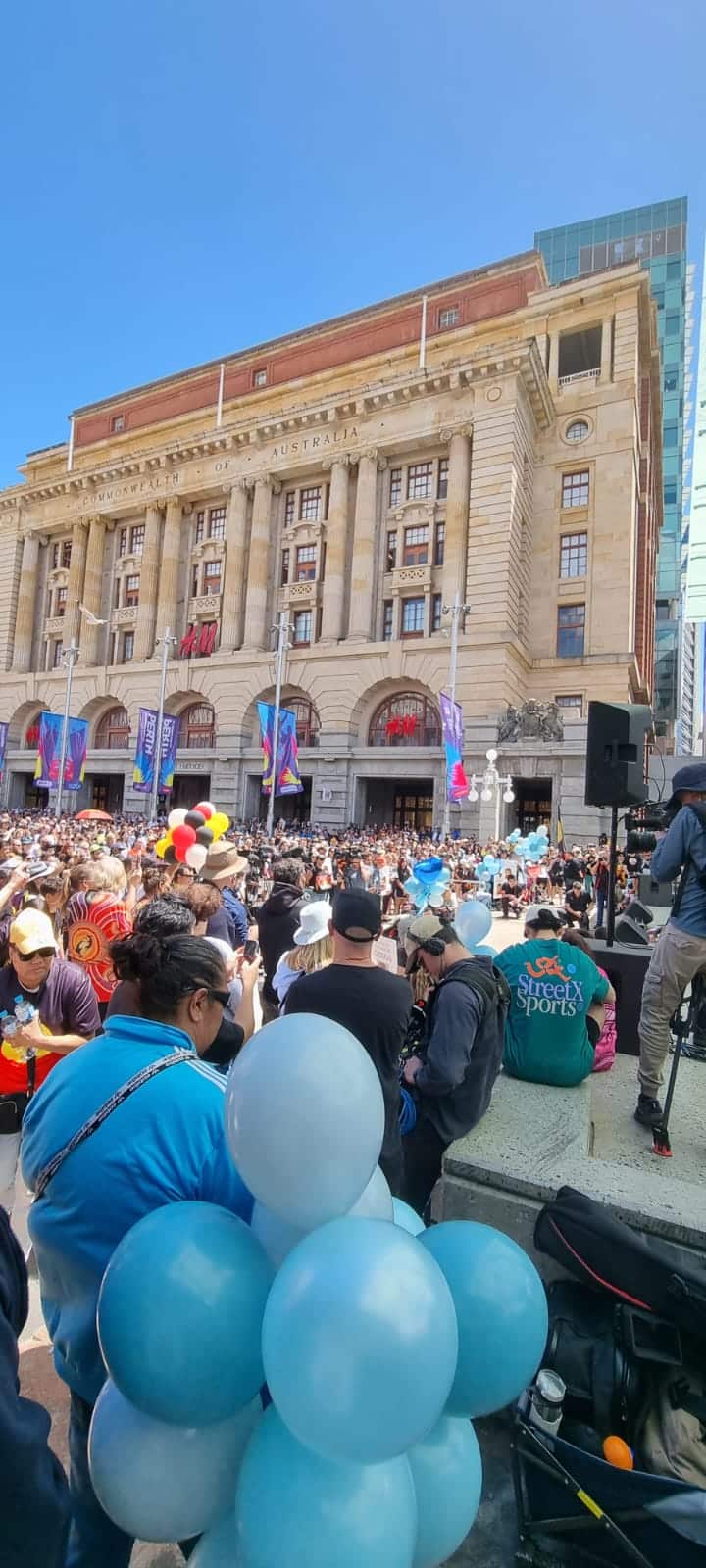 A crowd gathers in front of a platform