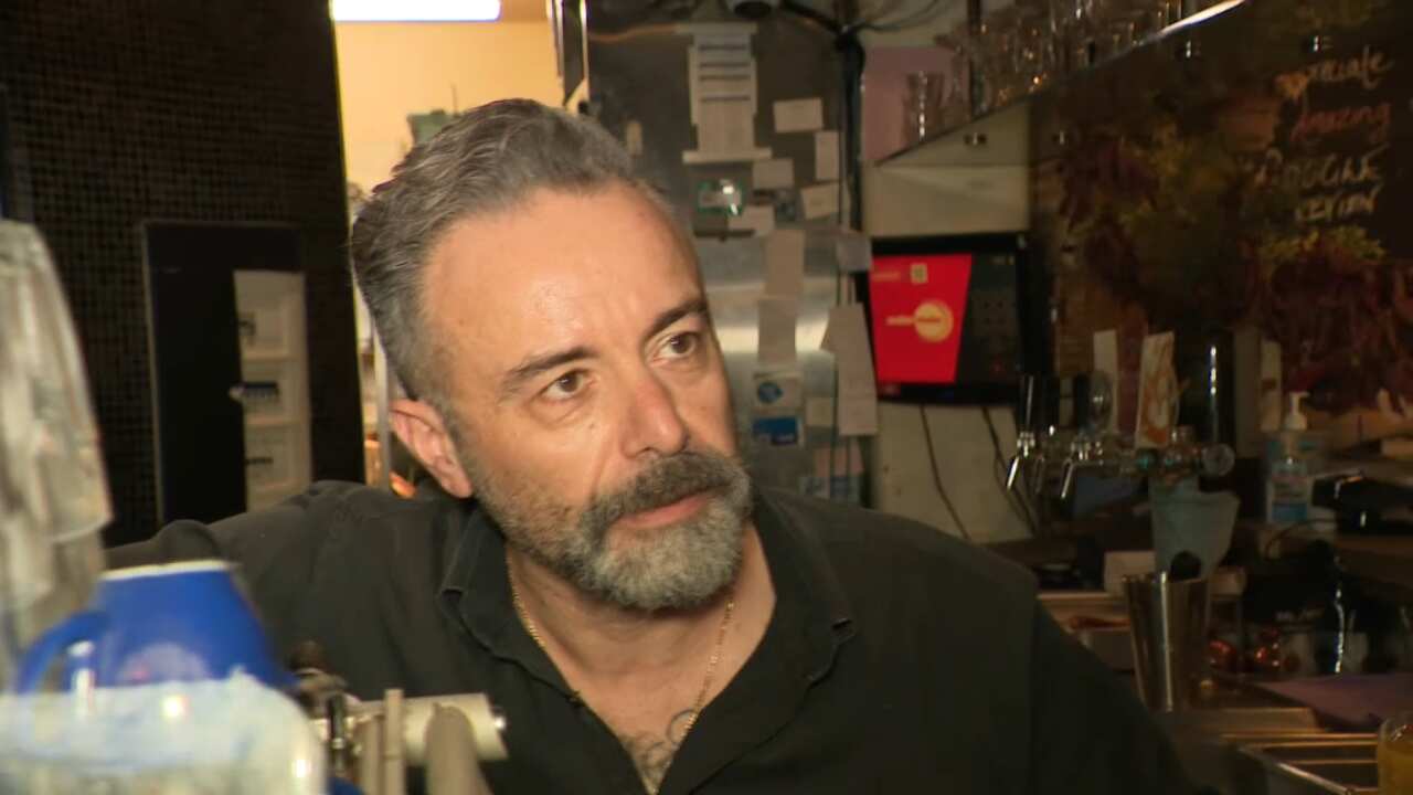 A man in a cafe staring to the side 