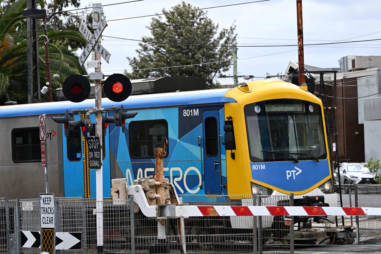 A Metro train passes a level crossing
