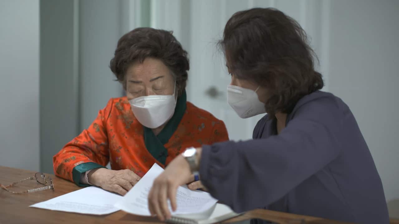 Two women reading paperwork.