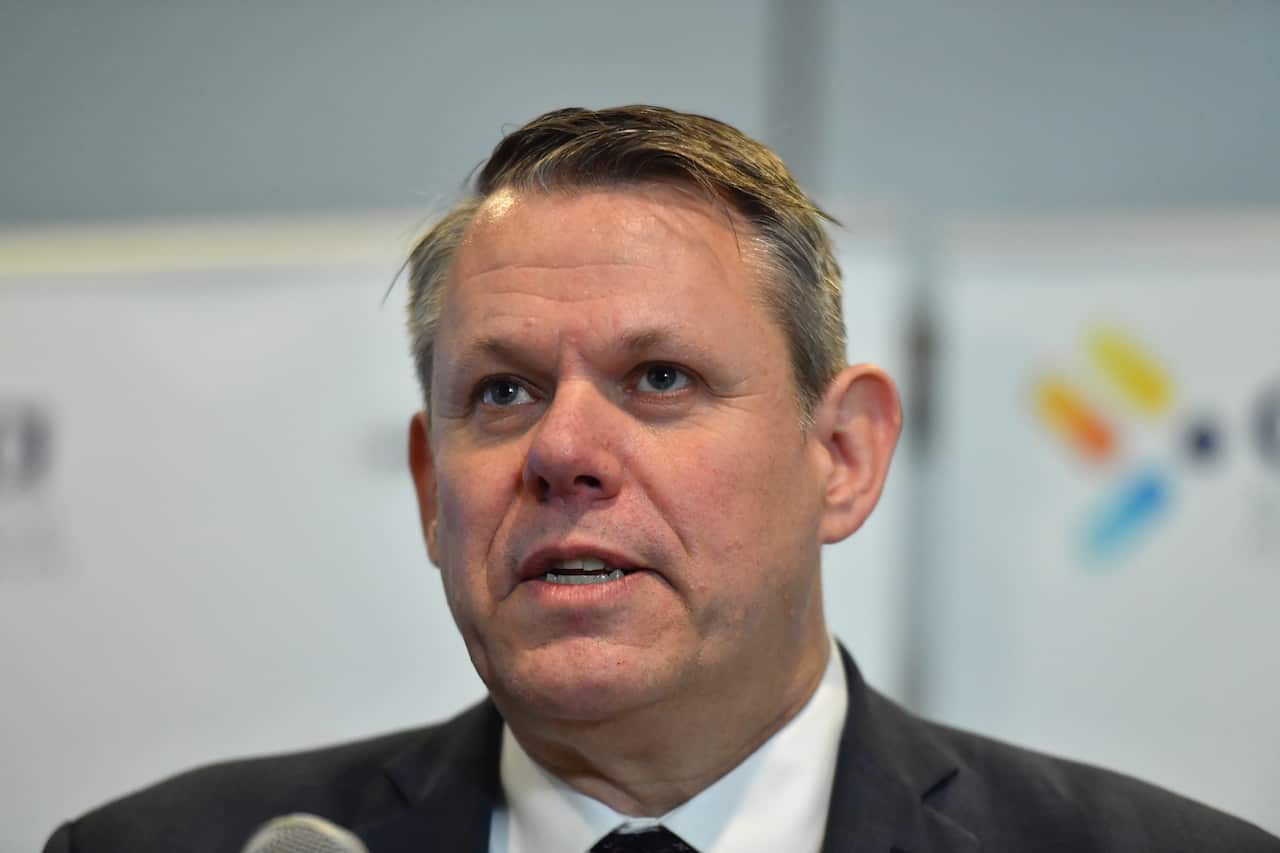 A man in a suit and tie talking into a microphone