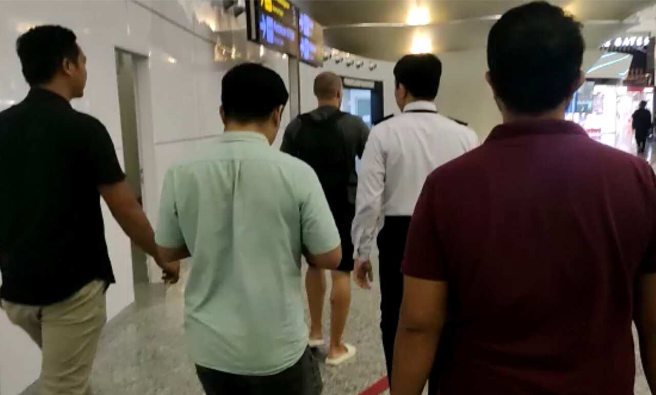 Five men walking through an airport