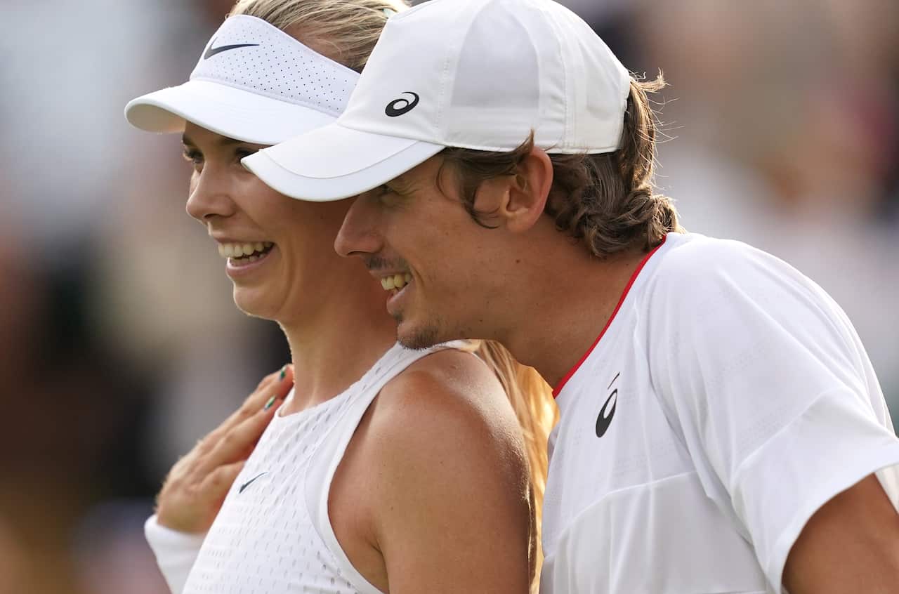 Close of up of two people's faces, with a male leaning over the shoulder of the female.