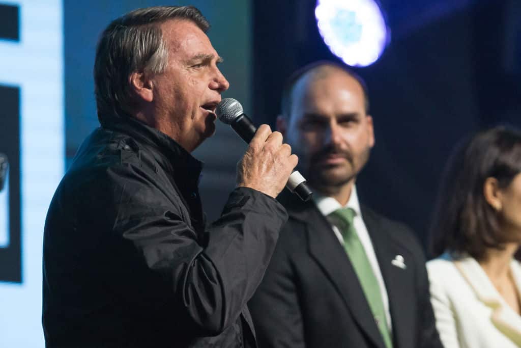 A man in a dark jacket holding a microphone 