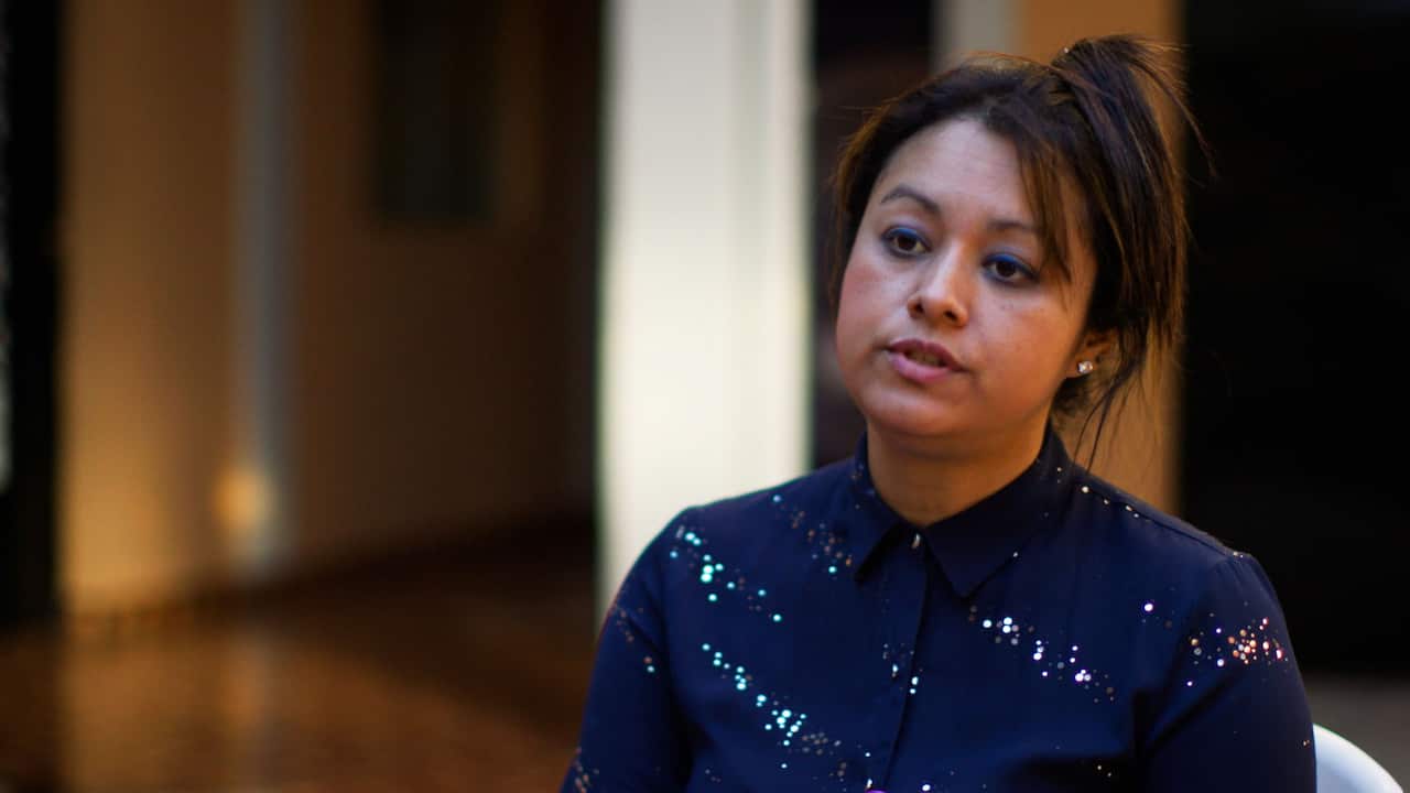 A woman wearing a sparkly blue shirt