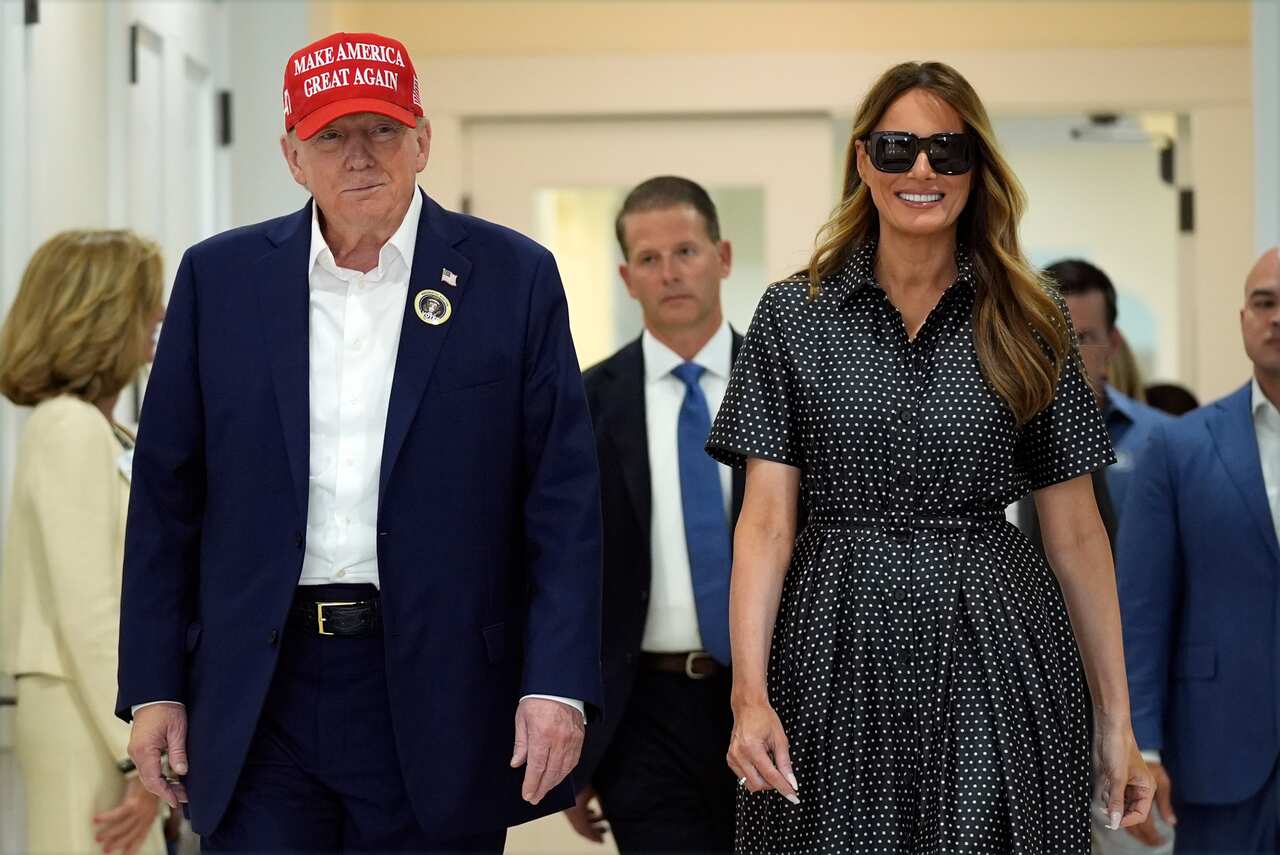 Donald Trump and Melania Trump are walking.