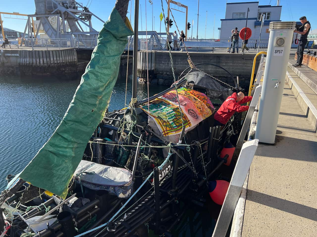 A man pushing his yacht out from a dock.