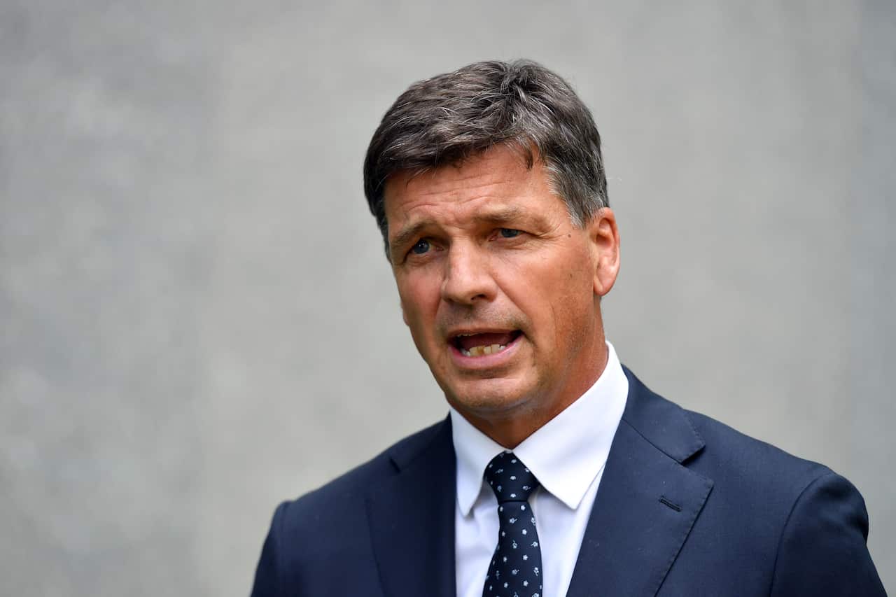 A man in a blue suit is speaking.