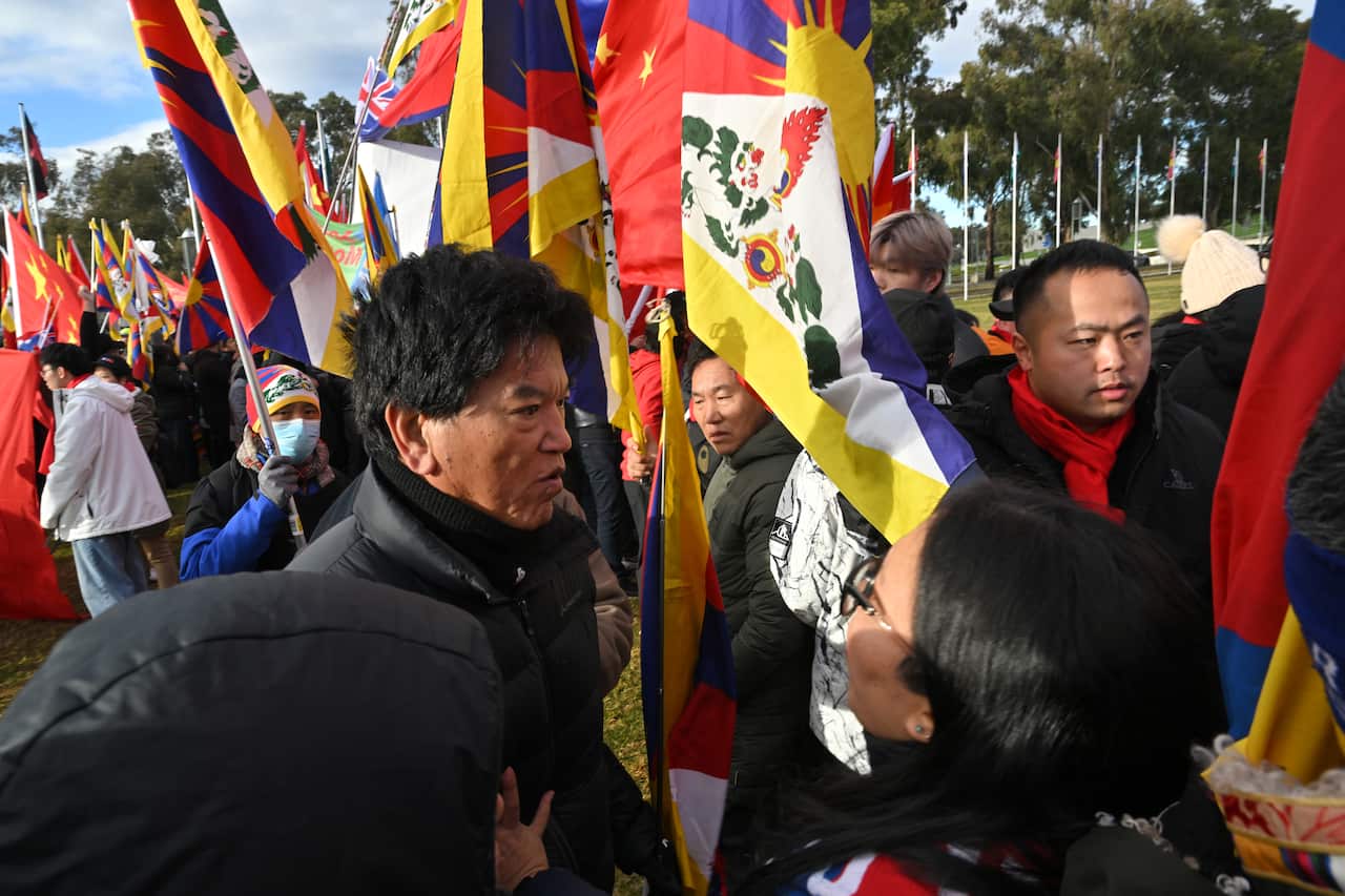 A group of people standing outside with flags