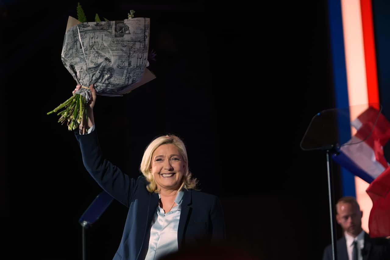 Marine Le Pen waves as she holds her last meeting during the campaign for president