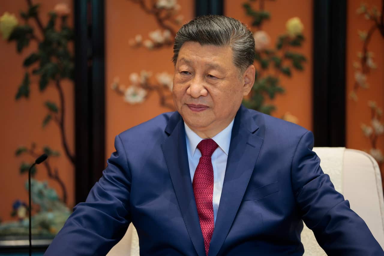 Xi Jinping wearing a blue suit and maroon tie