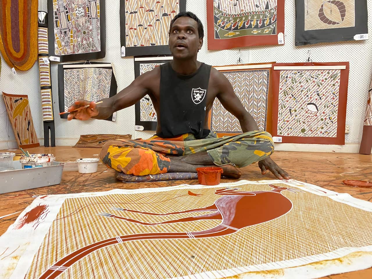 Yolngu artist Daniel Warrulukuma at Bula' Bula Arts painting Gandayala (red kangaroo), an important creation ancestor of Ramingining