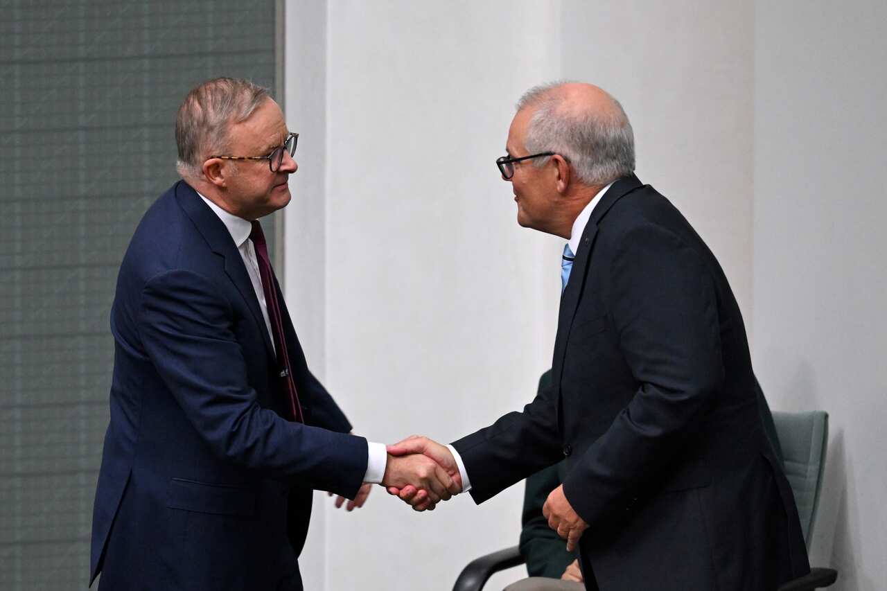 Two men shake hands. 