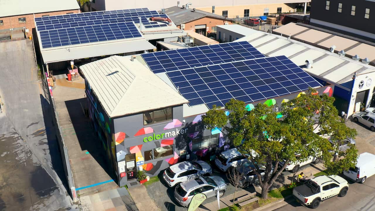 An aerial photo of a factory with solar panels on the roof.