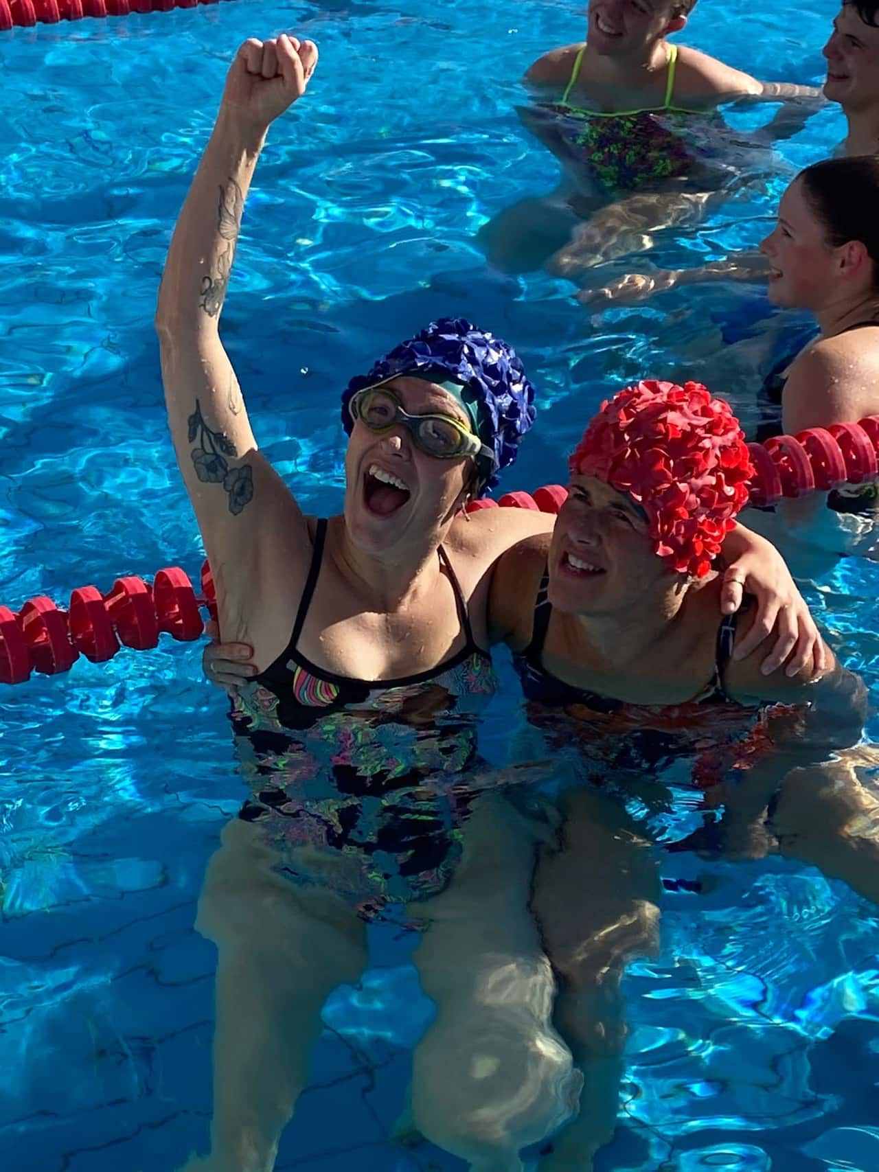 Swimmers in the water, smiling. 