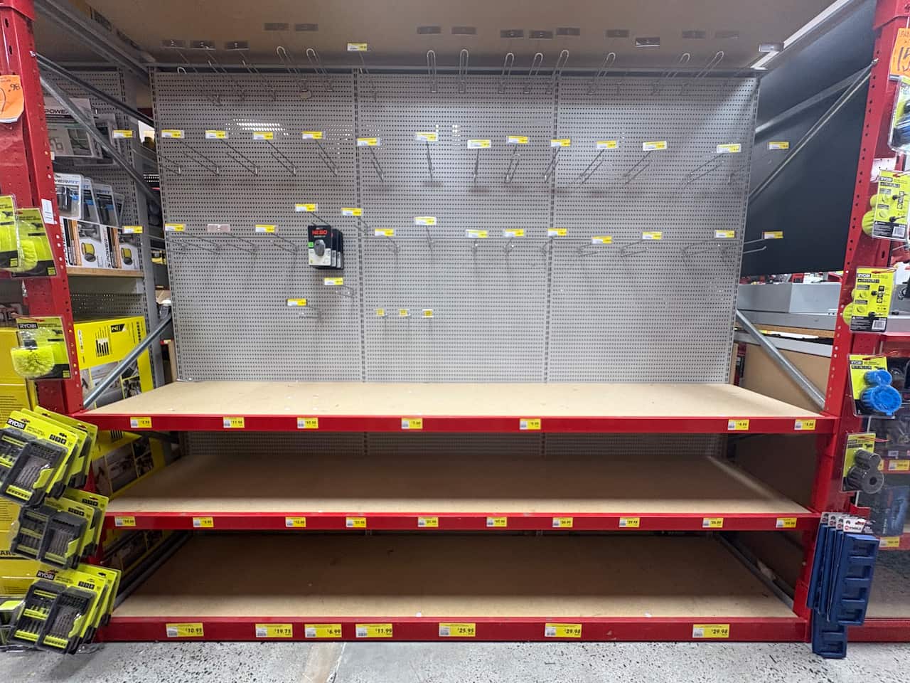 Empty shelves and hooks in a hardware store.