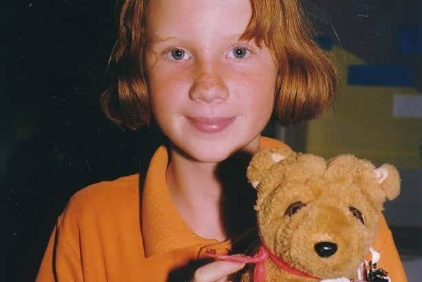a little girl holding a teddy bear