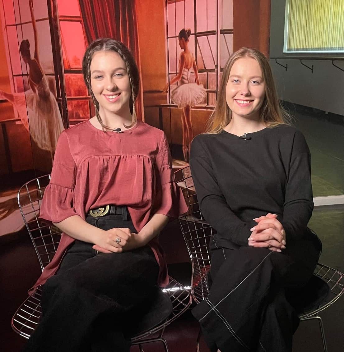 Two women sitting on chairs and smiling