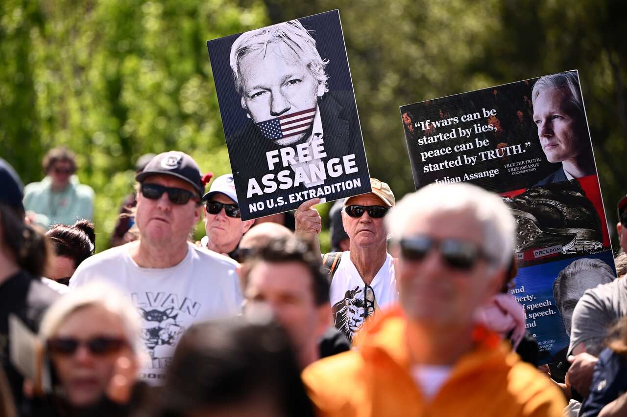 A group of demonstrators. One is holding a sign that reads "FREE ASSANGE: NO U.S. EXTRADITION".