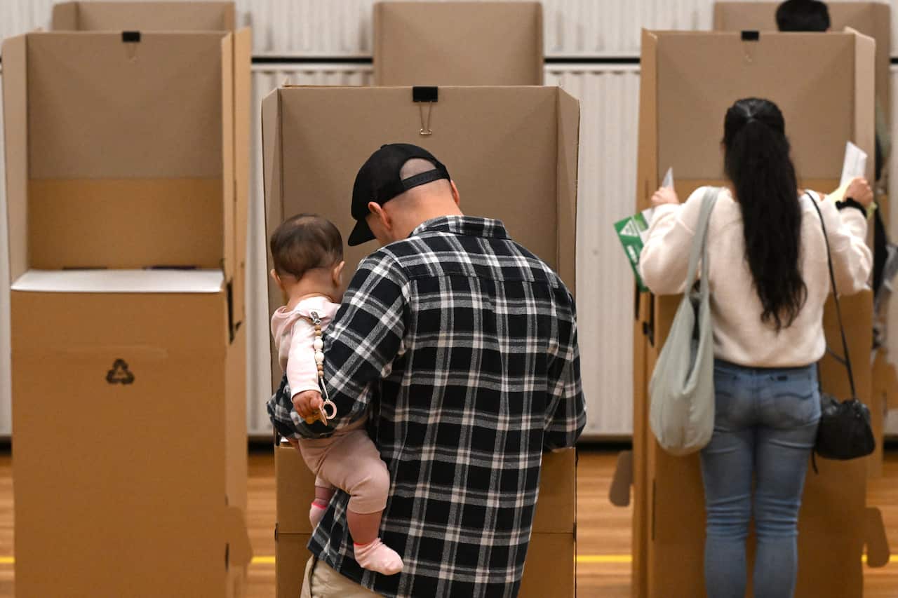 People filling out ballot papers for an election.