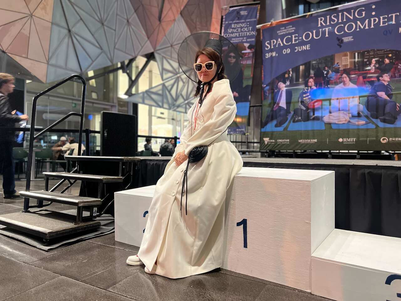 A woman in South Korean traditional dress sitting on a podium