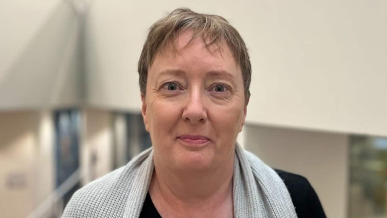 a closeup of an older woman with short hair in an office