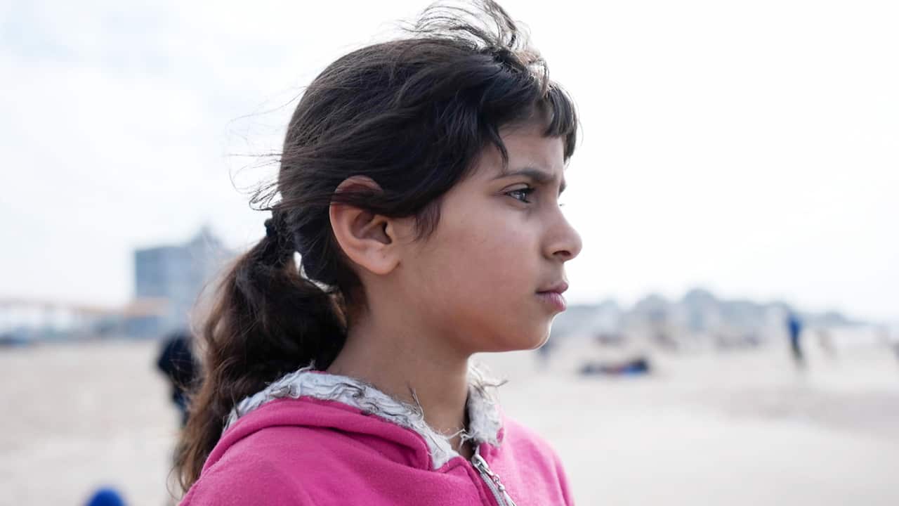 A profie photo of a girl with a ponytail wearing a pink hoodie 