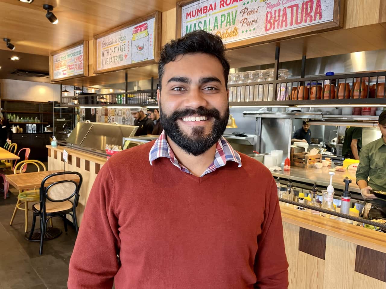 A man infront wearing a red jumper.