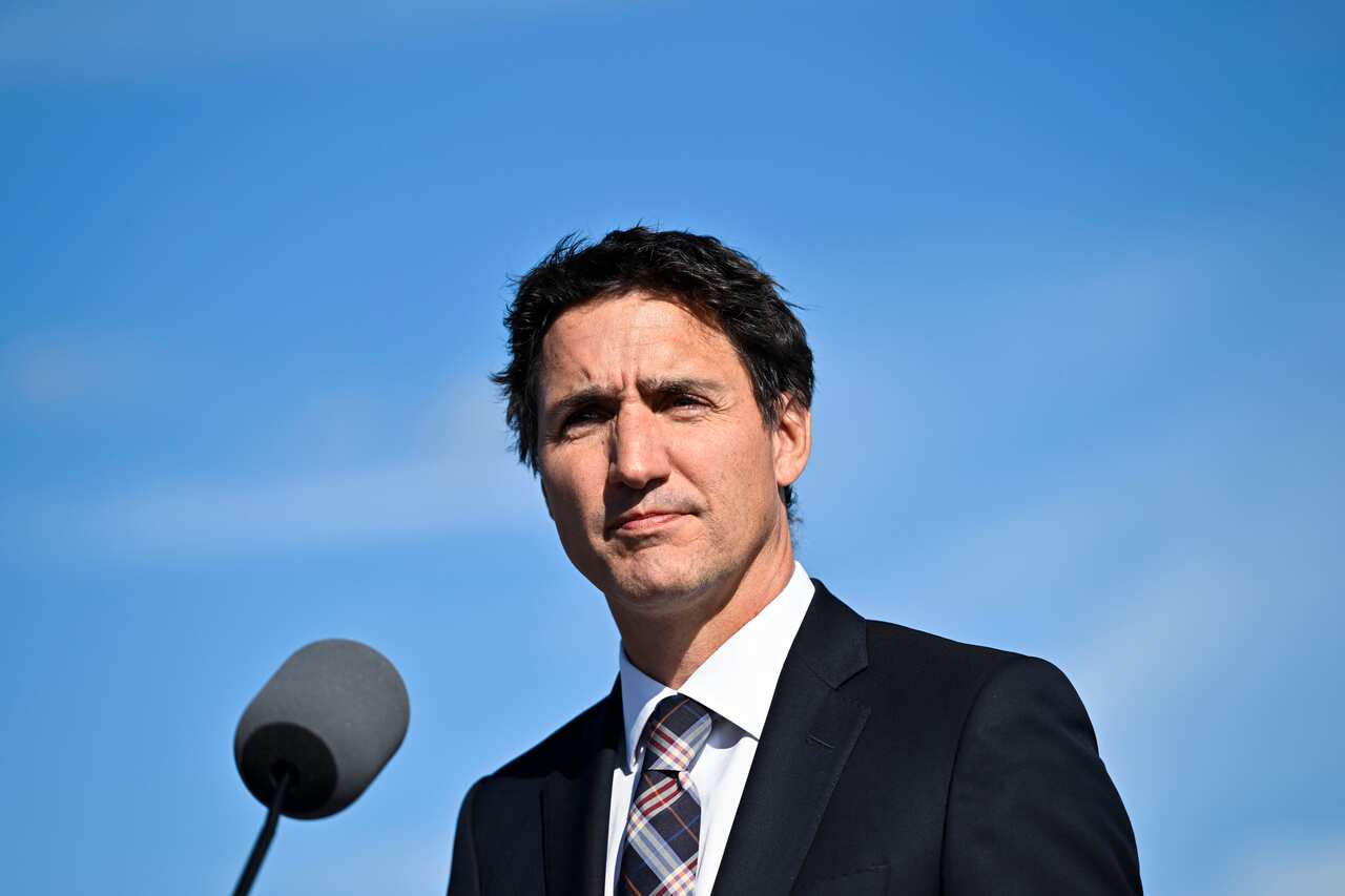 Justin Trudeau stands at a microphone