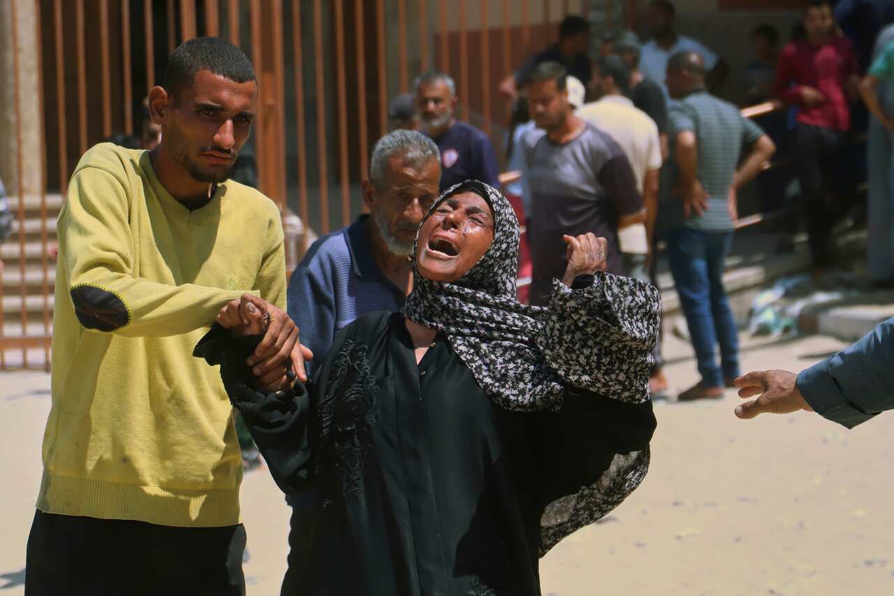 A woman crying out, as a man holds her hand.