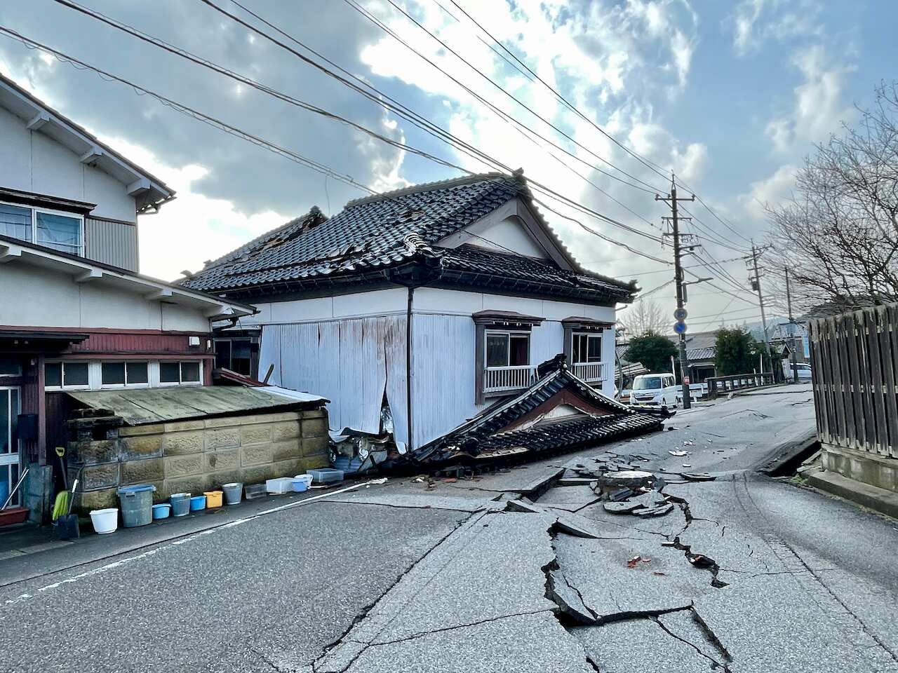 A destroyed heritage building with a heavily cracked road in front.