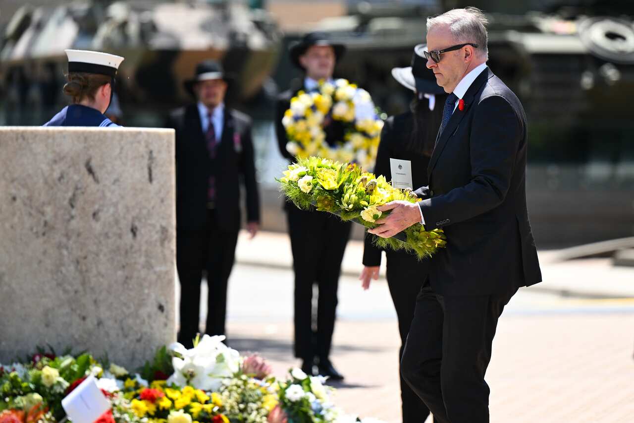 Anthony Albanese lays a wreath as soldiers stand in the background.