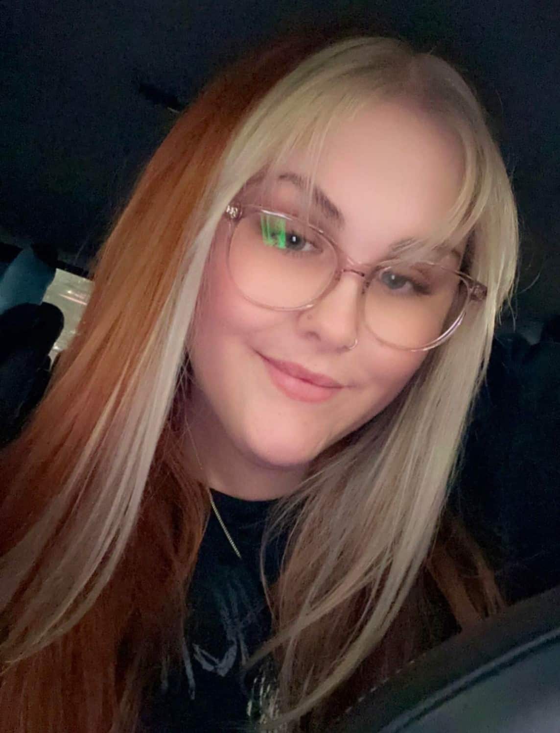 A young woman wearing glasses taking a selfie