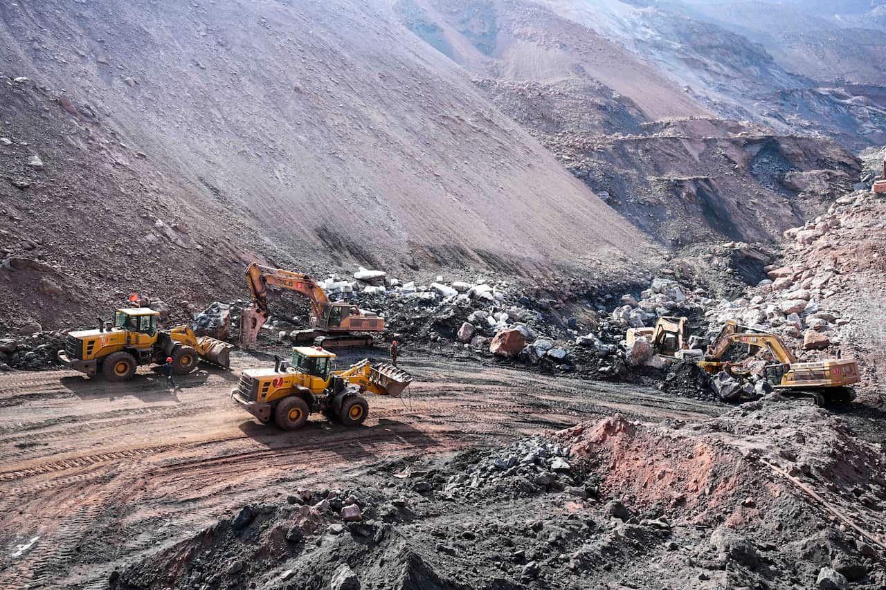 A collapsed open-pit coal mine with bulldozers around