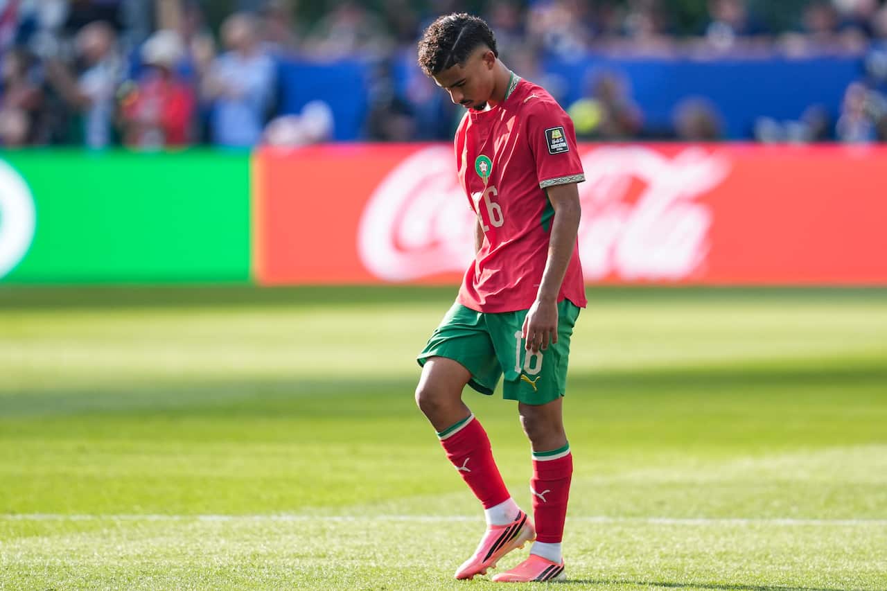 A Moroccan football player in red looking dejected