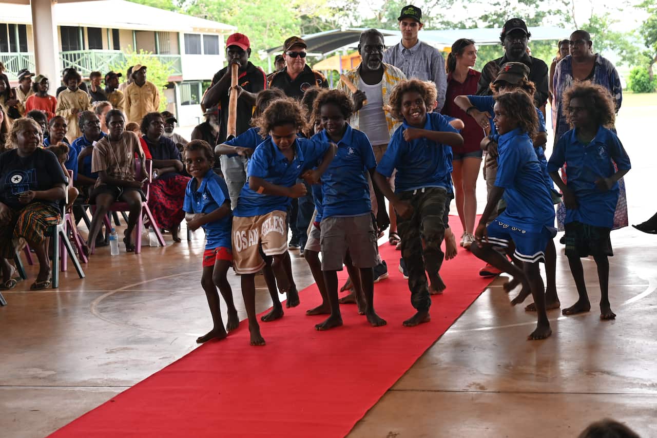 Children and families dance in the graduates with clapsticks and didgeridoo