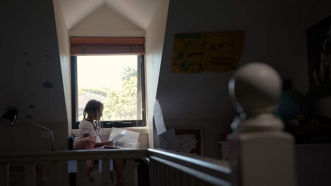 Liora reads in her bedroom.