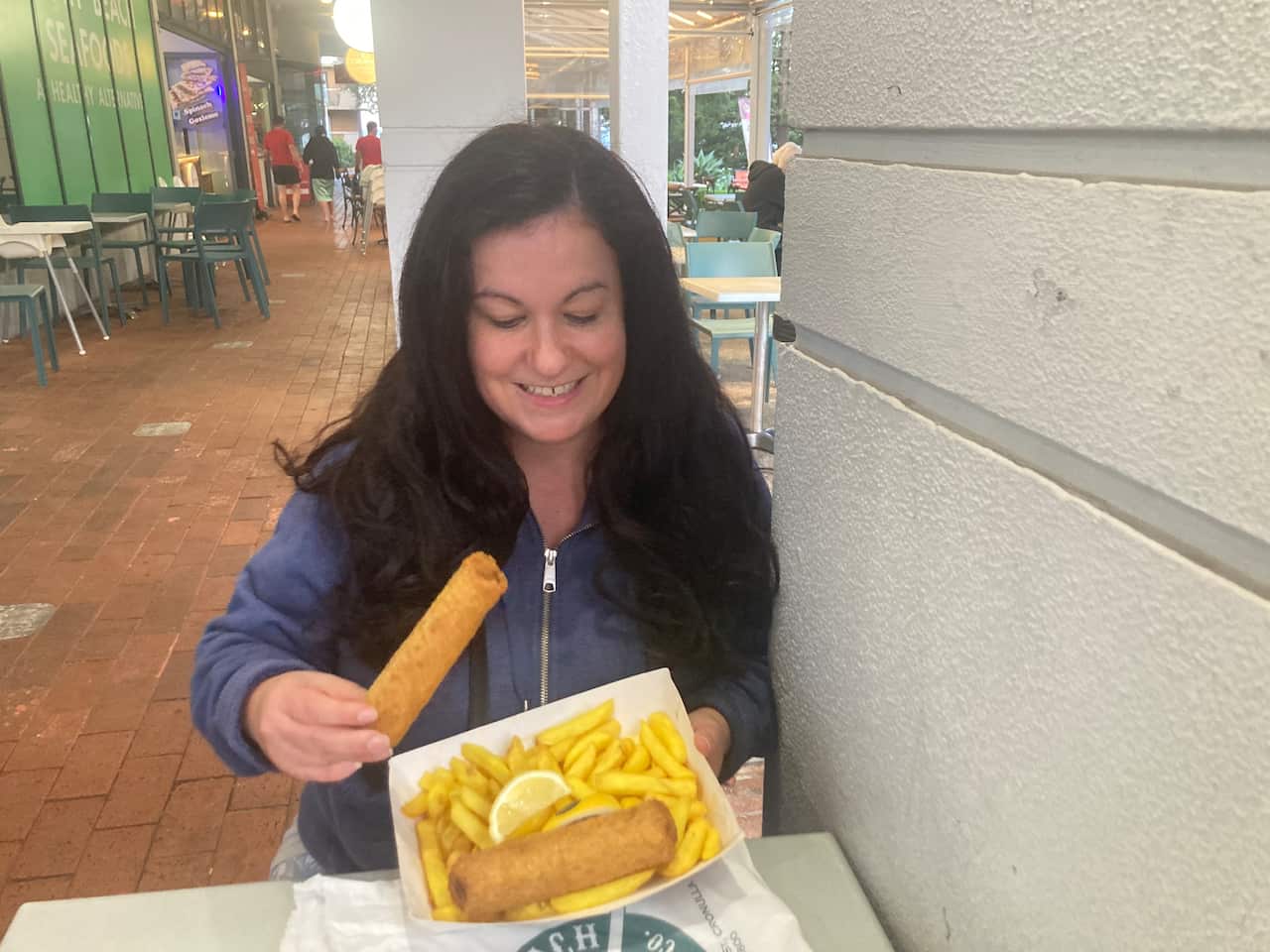Female ready to eat a Chiko roll as part of a takeaway meal.JPG
