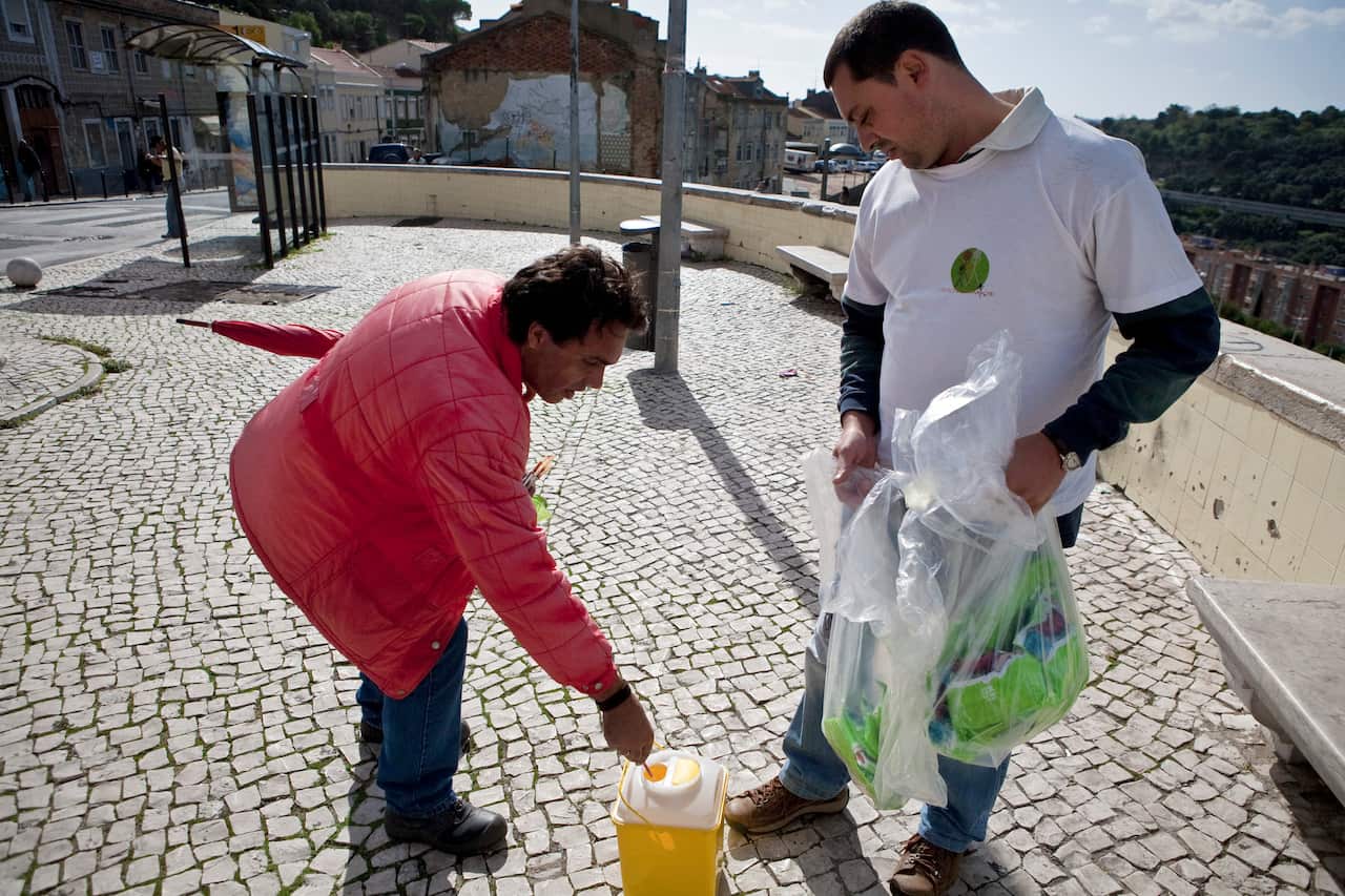 Man places used needles in a container.