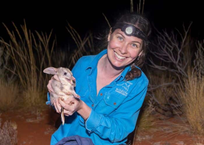 A woman holding a bilby.