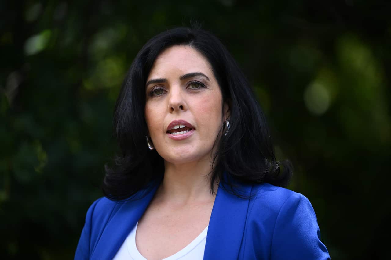 A woman with black hair wearing a blue blazer.
