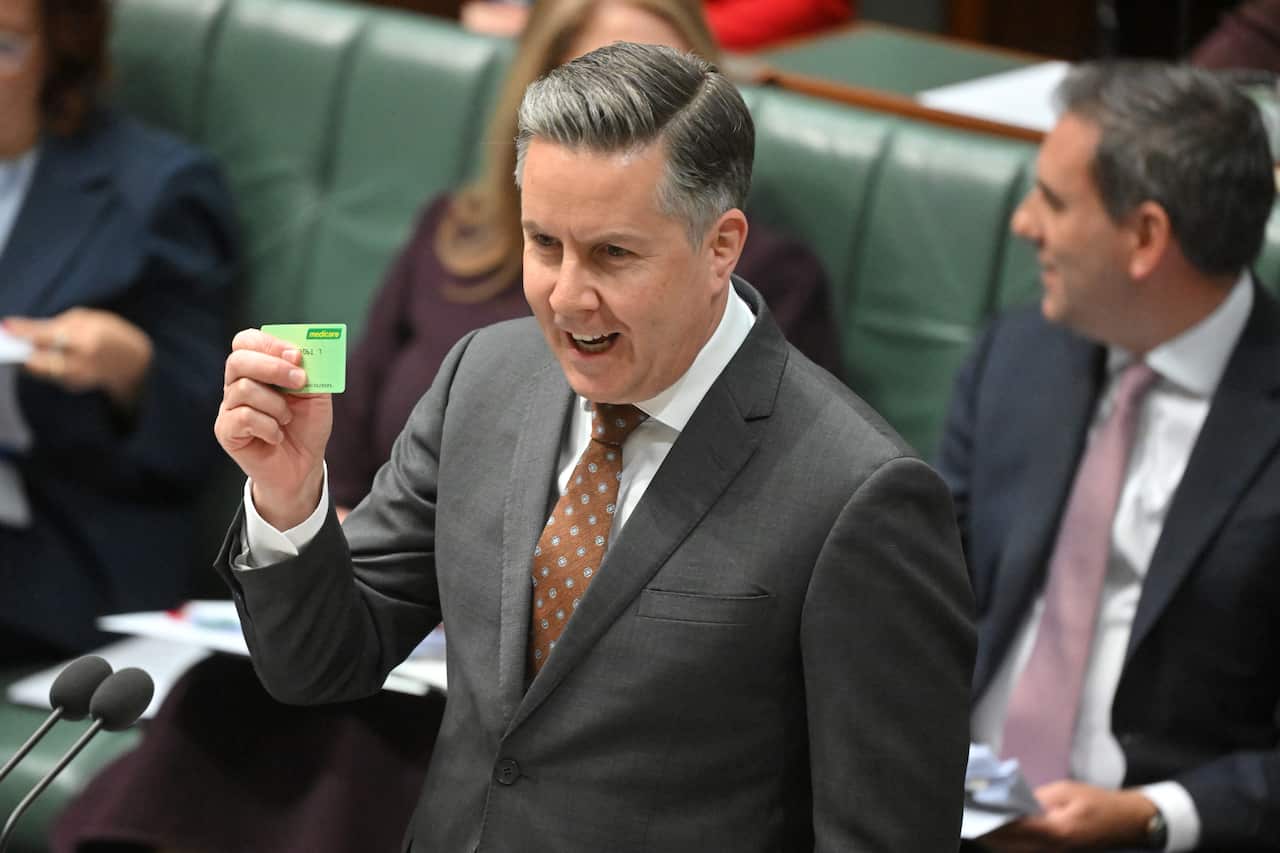 Health Minister Mark Butler holds up a concession card while speaking in the House of Representatives.
